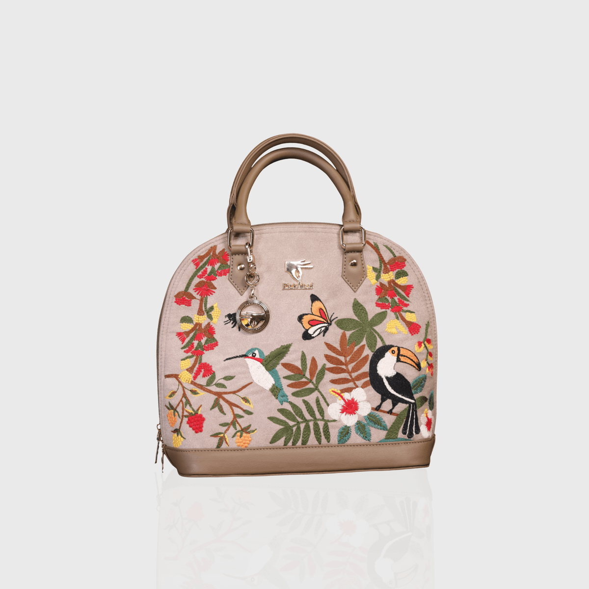 Beige floral vegan leather top handle bag from the Mystic Garden Collection displayed on a plain surface